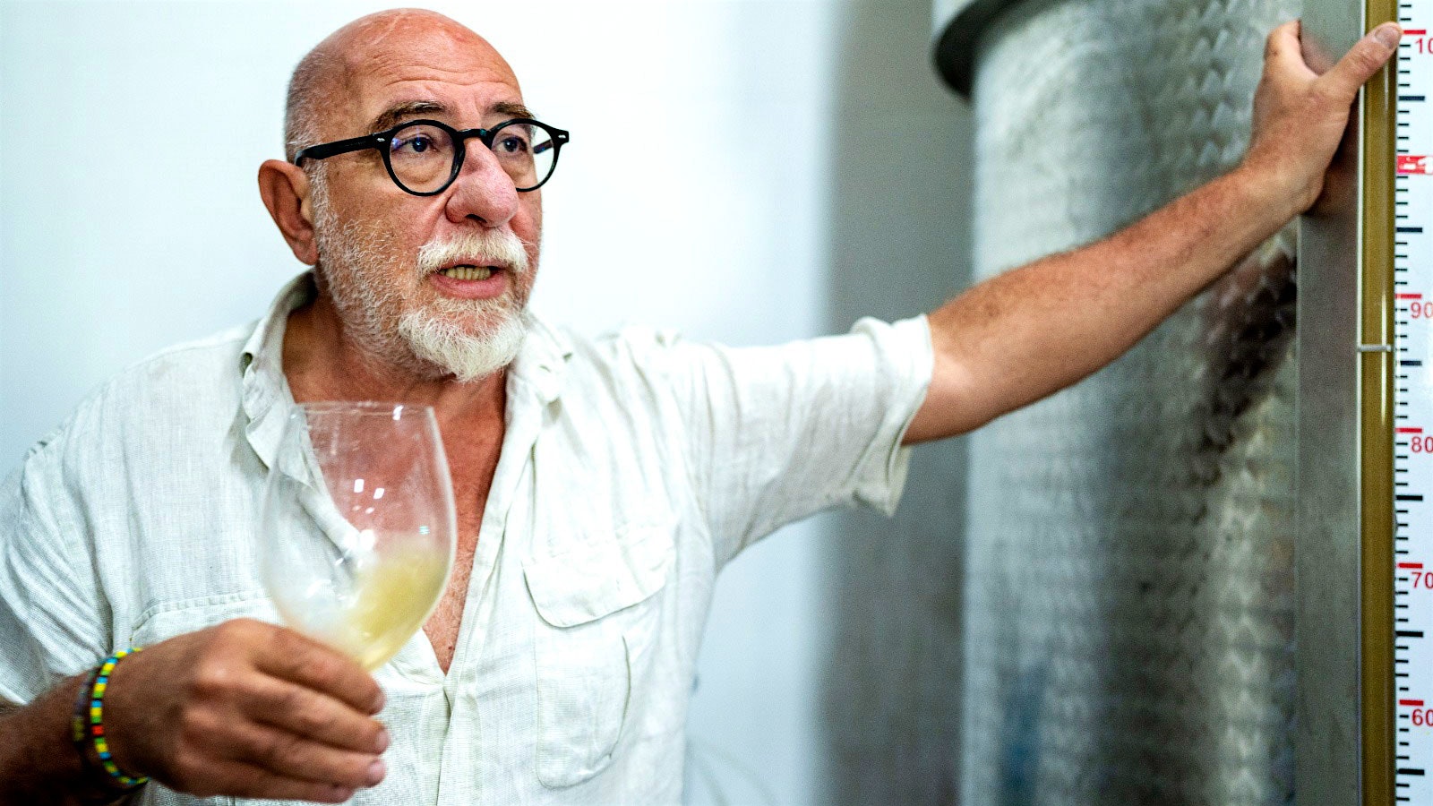 Bruno De Conciliis in his winery tank room, holding a glass of white wine